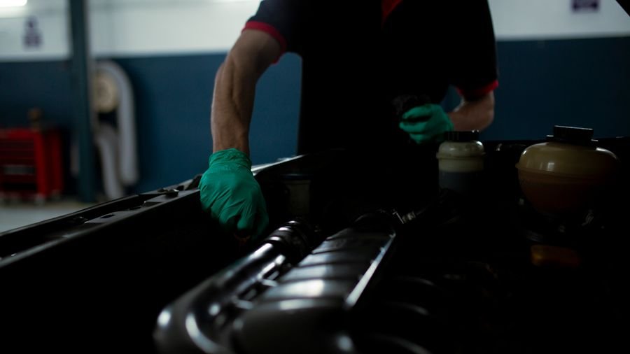 Mecánico revisando el motor de un vehículo en un taller iluminado