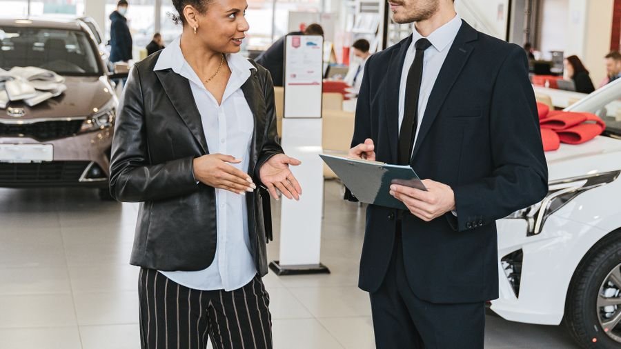Asesor y cliente revisando detalles en la sala de ventas de un concesionario