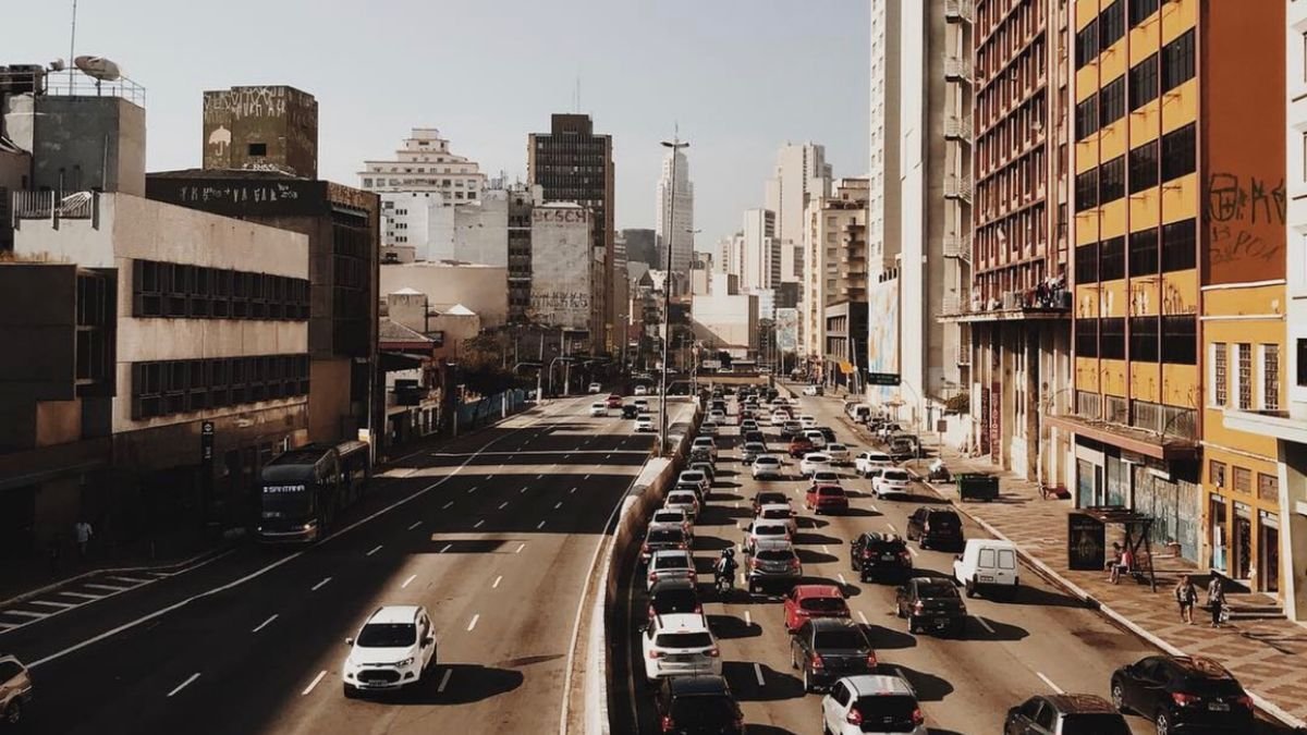 Carros circulando en una avenida amplia de la ciudad al mediodía