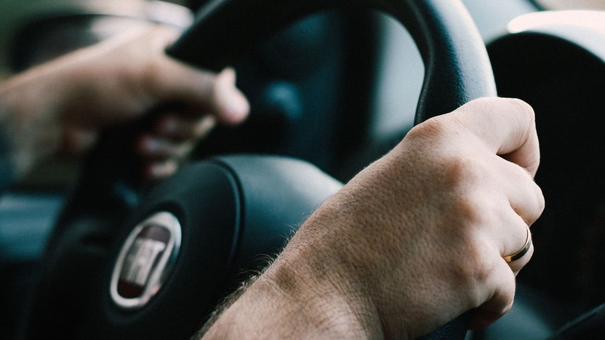 Manos firmes sobre el timón de un carro, listas para conducir