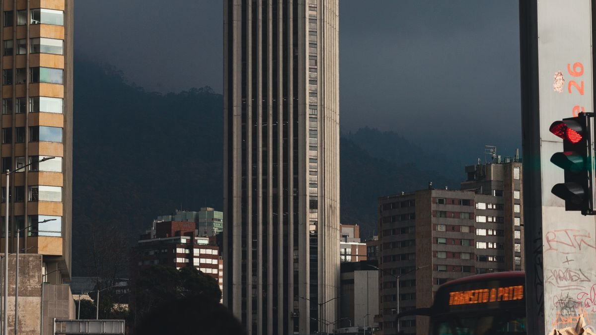 Semáforo en rojo frente a los edificios del centro de Bogotá con los cerros de fondo