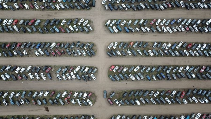 Vista aérea de un lote enorme con cientos de carros estacionados en filas