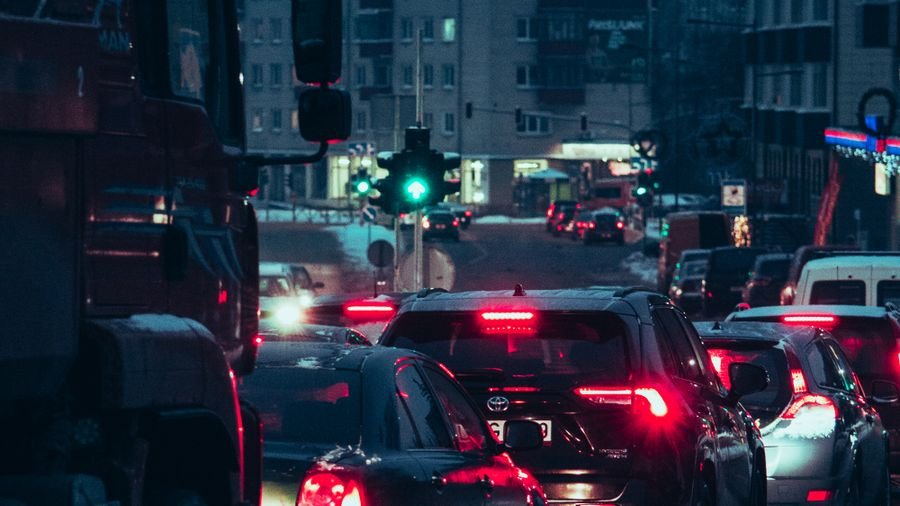 Tráfico denso con luces de freno encendidas en una avenida al anochecer