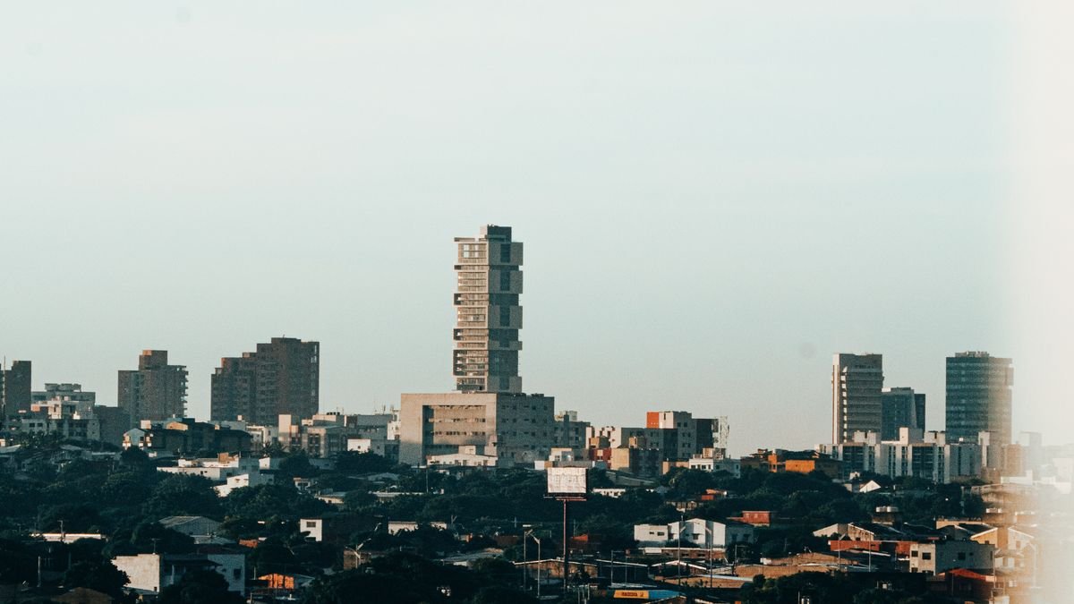 Perfil urbano de Barranquilla con edificios y barrios al atardecer