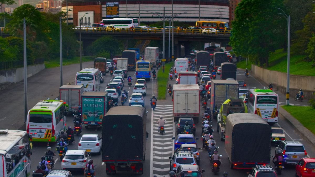 Tráfico denso de carros, buses y motos en una vía de Medellín