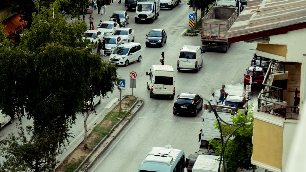 Vista elevada de una calle urbana llena de tráfico y personas