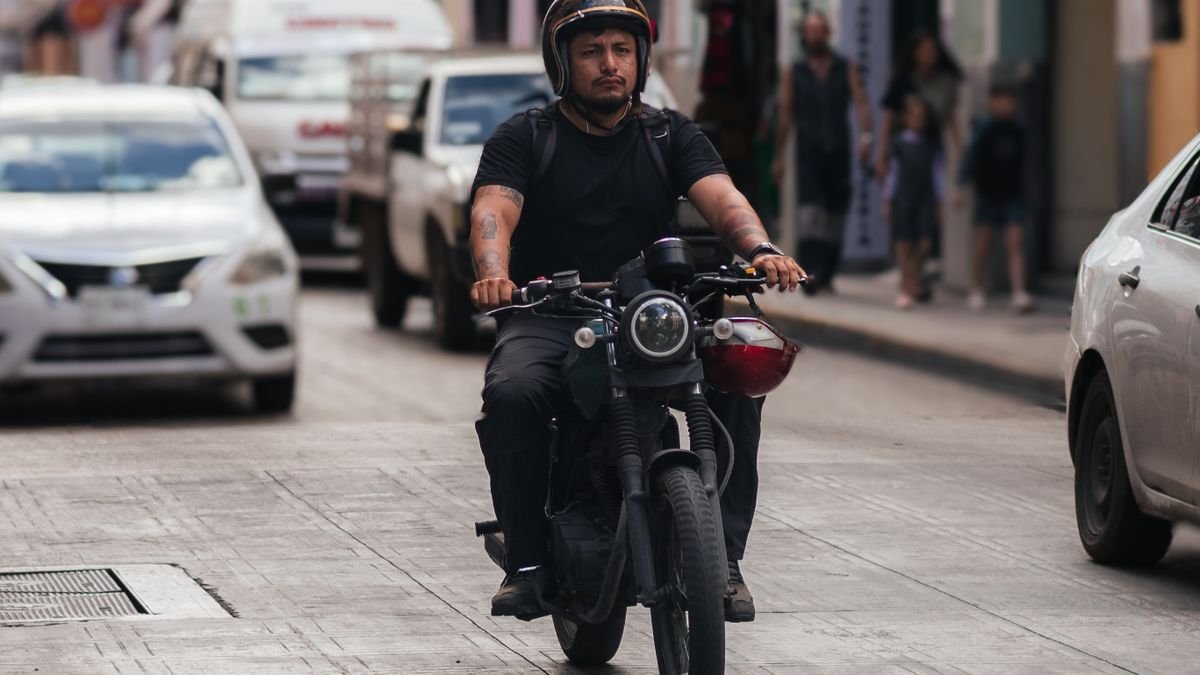 Motociclista circulando por una calle concurrida de la ciudad