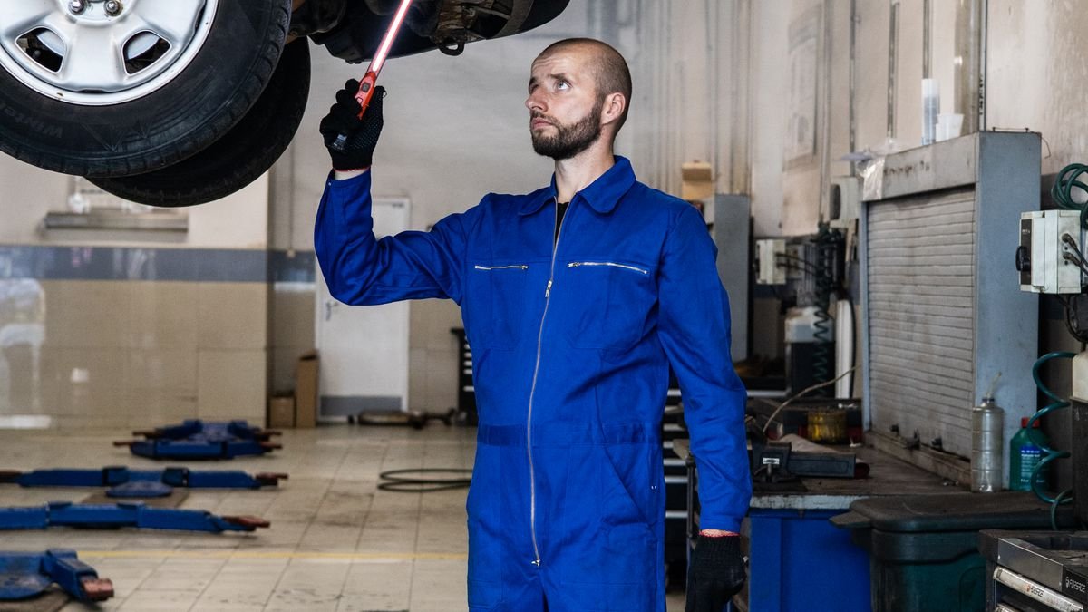 Técnico revisando los bajos de un vehículo en un centro de diagnóstico
